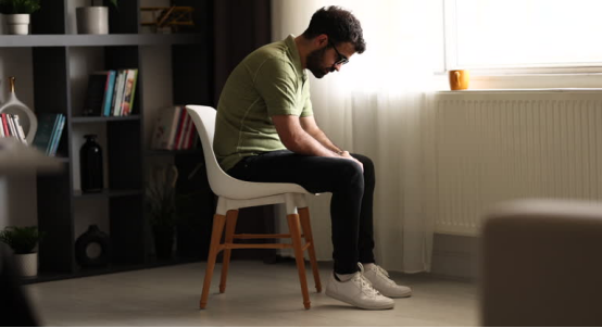 Man feels fatigued after long sitting, while a bamboo charcoal donut pillow offers ultimate comfort and relief