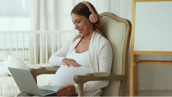 Pregnant woman uses a donut pillow for supportive sitting, enhancing comfort during pregnancy