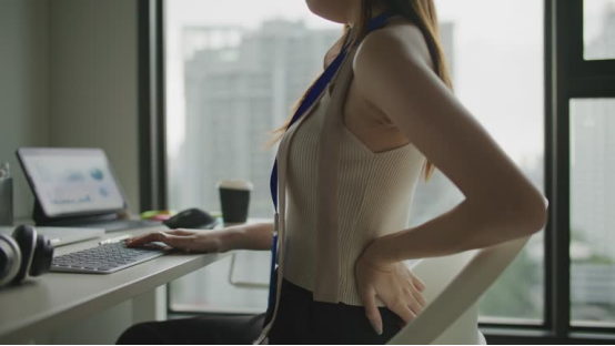 Office worker uses a donut pillow to relieve back discomfort, upgrading workspace comfort with style