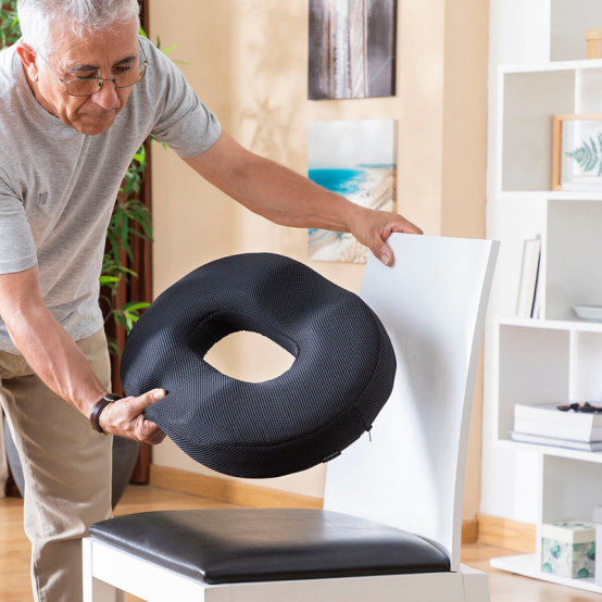 A senior placing a donut pillow on a chair, embracing comfort as part of a slow living routine.