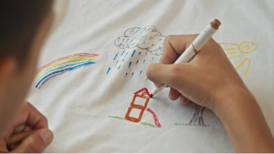 This child uses a donut pillow to stay focused while drawing, turning at-home creative learning into a more focused activity.