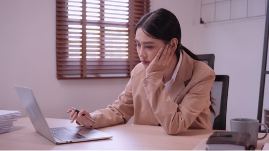 A fatigued office worker at her desk, showing how a memory foam donut pillow eases burnout-related discomfort.